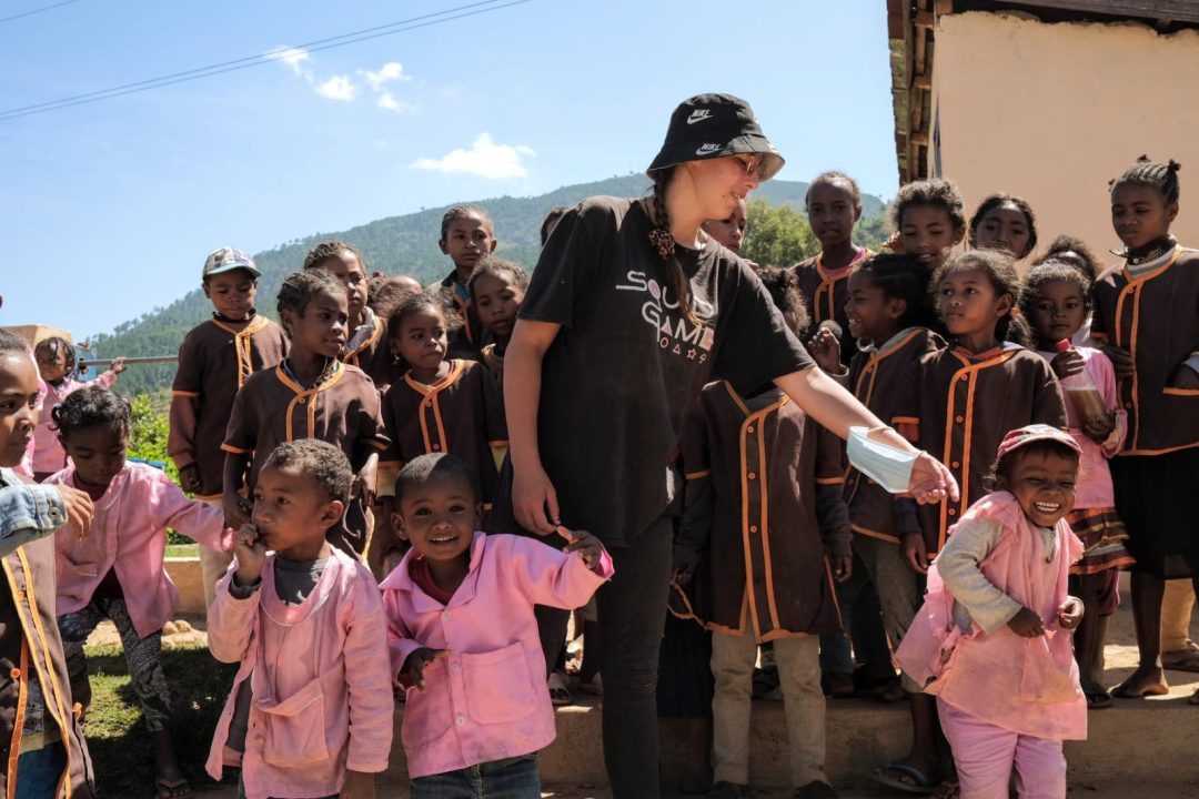 Une volontaire de Manda Spring entourée d’enfants d’une école à Madagascar, lors d’une activité de terrain
